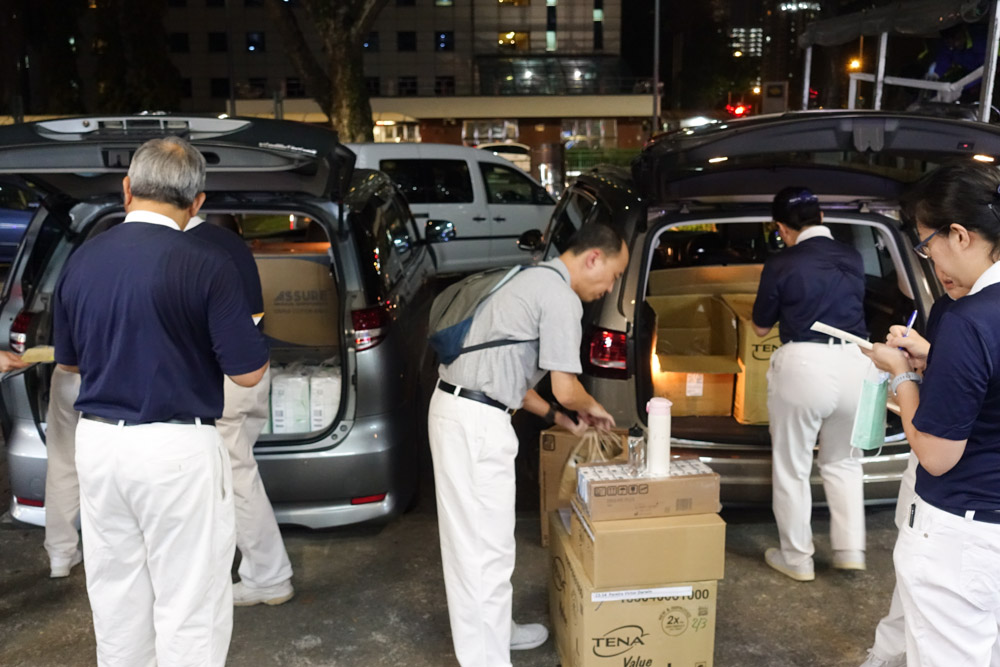 After the briefing, volunteers move the relief materials into their own vehicle to send to the respective care recipients. (Photo by Bernard Ng Jia Han)